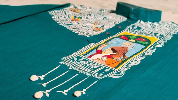 Hand-painted teal cotton kurta featuring a traditional folk art motif with white decorative borders and a colorful central illustration, showcasing intricate handcrafted detailing.